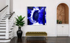 Modern interior with abstract blue artwork on a white wall, green bench, and plant.