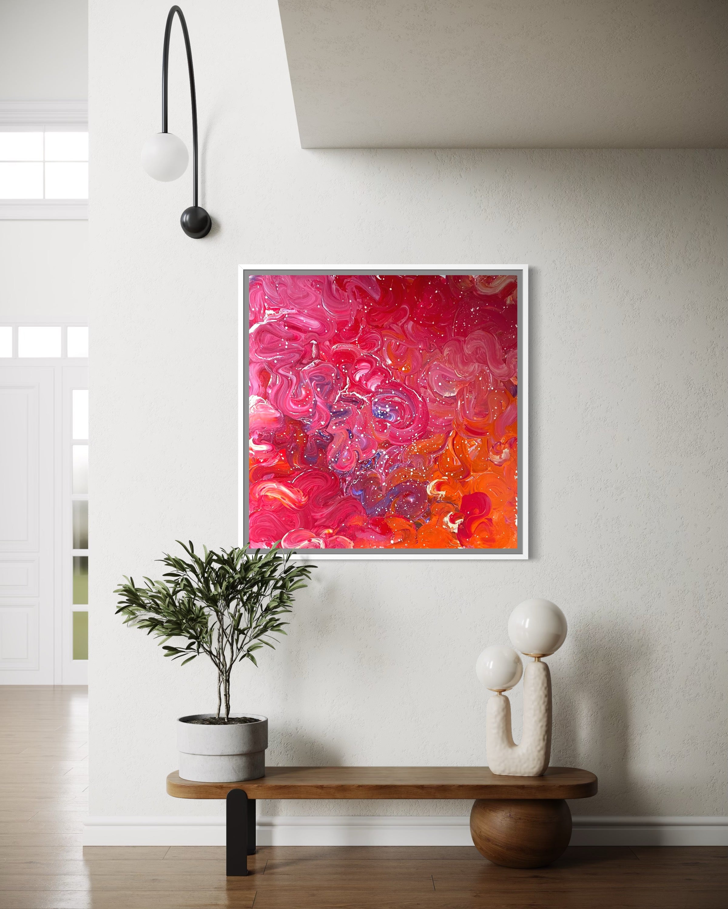 Framed abstract painting with pink and orange hues in a modern interior setting.