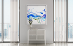 Modern interior with abstract art on a wall, white console table, and large windows.
