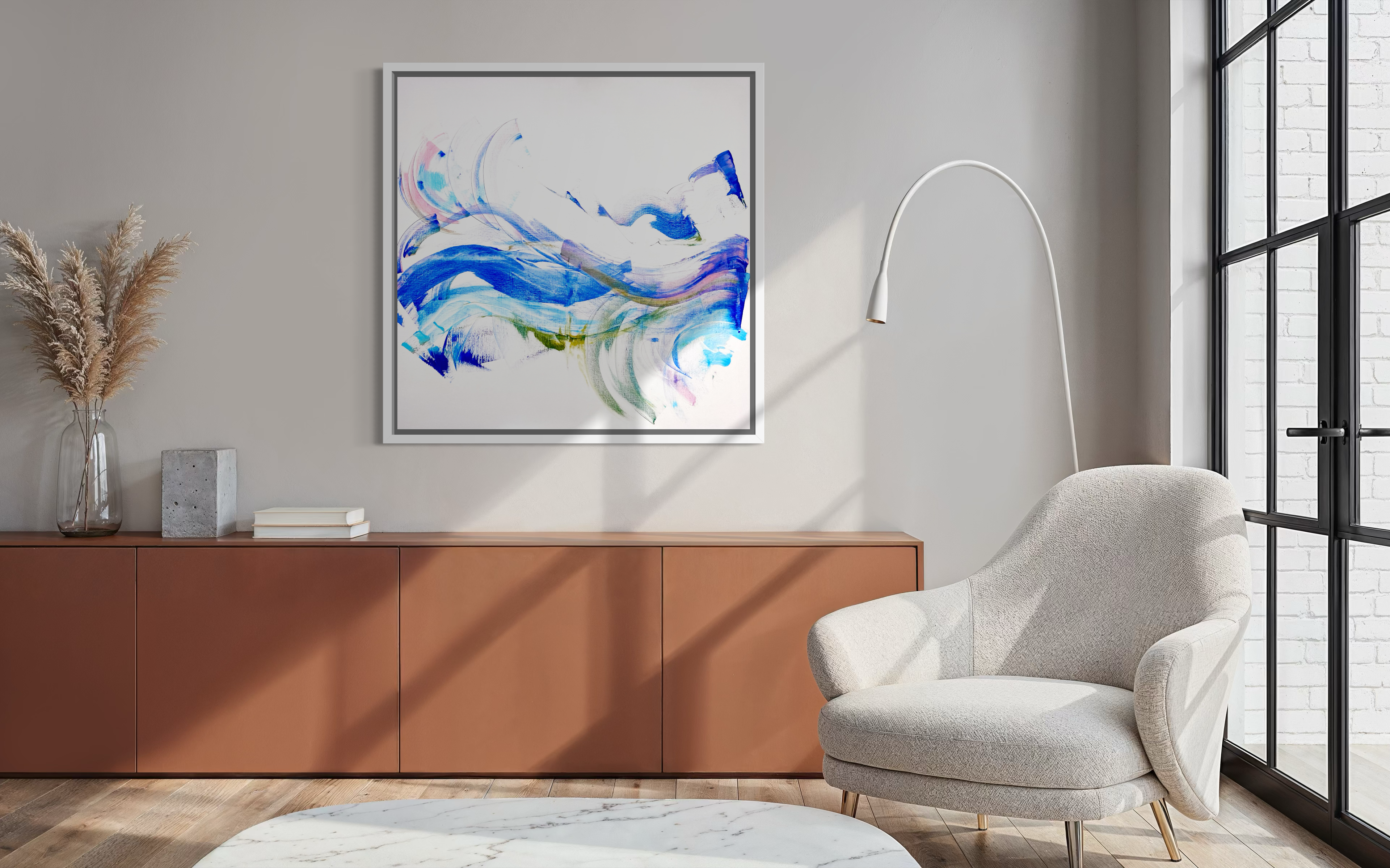 Modern living room with a gray armchair, wooden cabinet, and abstract art on the wall.
